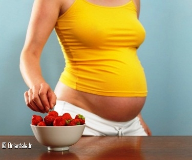 Femme enceinte choisissant une fraise Femme enceinte choisissant une fraise