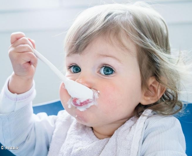 Petit bébé mangeant seul un yaourt Petit bébé mangeant seul un yaourt